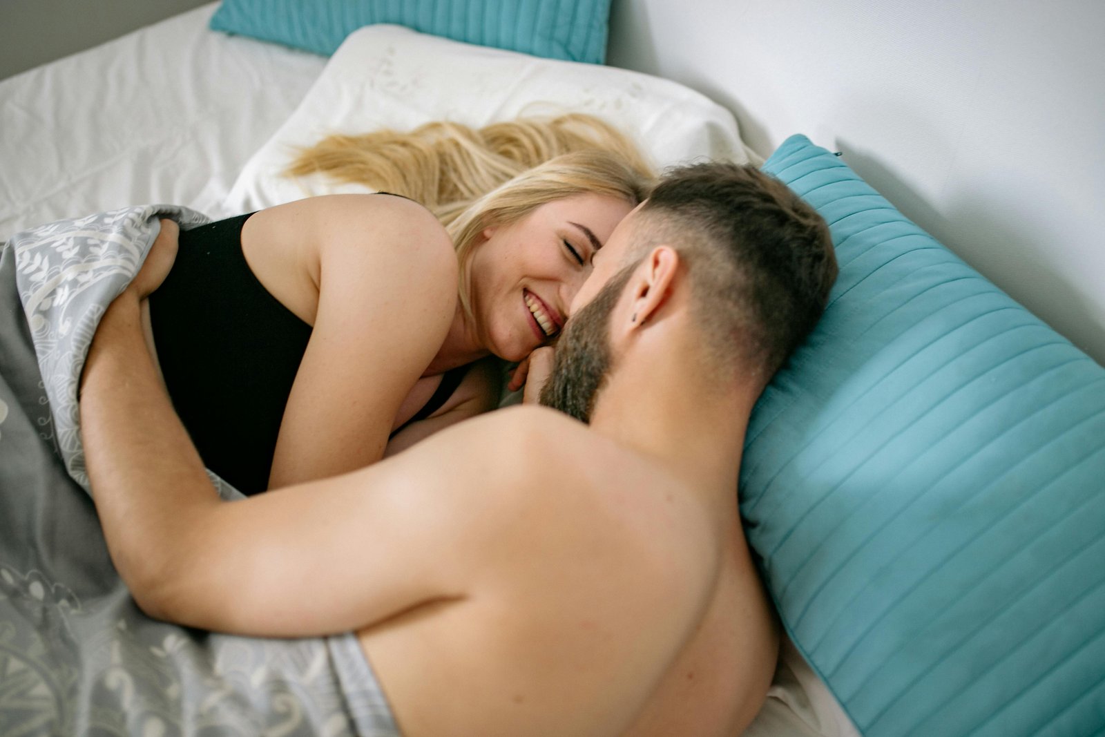 Hombre y mujer abrazados en la cama como programa de bienestar