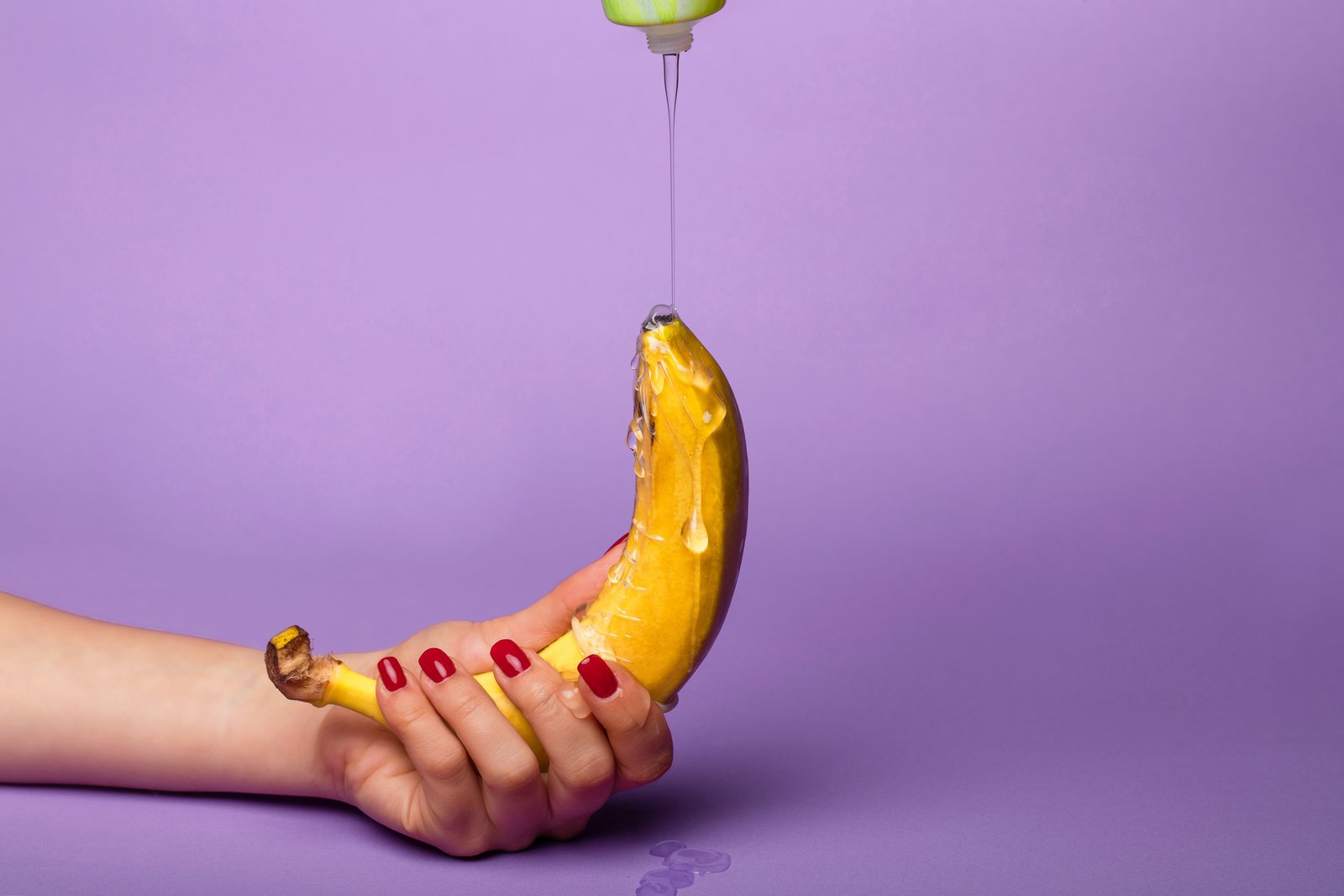 Se pasa el lubricante sobre un plátano sostenido por una mano